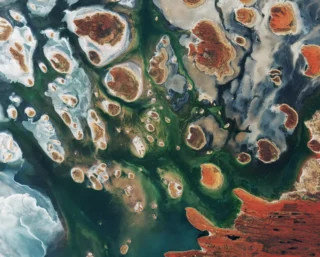 Brown hills speckle the eastern part of Australia’s Lake MacKay in this satellite image.